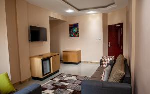 a living room with a couch and a tv at HOTEL MICKEL in Douala