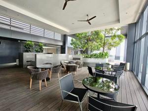 un hall avec des tables et des chaises dans un bâtiment dans l'établissement KL Eco City Apartment by Homeizing, à Kuala Lumpur