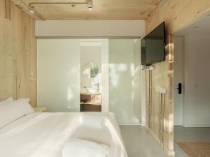 a bedroom with a bed with a tv and a tub at Hotel Amiuka in O Pedrouzo