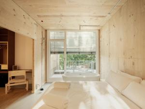 a bedroom with a bed and a tub in a window at Hotel Amiuka in O Pedrouzo