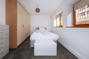 um quarto branco com uma cama e uma janela em Exhilarating 2BD Flat with Outdoor Patio Dublin! em Dublin