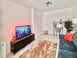 Una sala de estar con un sofá azul y un televisor de pantalla plana. en Sector3 Modern Living and Terrace, en Bucarest