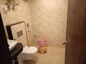 a bathroom with a white toilet and a sink at Hotel The Tark Near IGI Airport Delhi in New Delhi