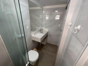 a bathroom with a toilet and a sink and a mirror at APARTAMENTO FRENTE MAR in Itapema