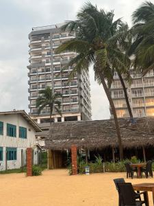 a building with a palm tree and a table and chairs at Blue Ocean in Dehiwala