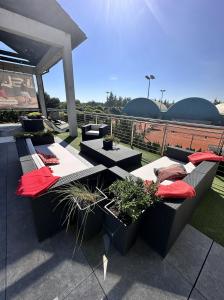 a patio with couches and potted plants on a roof at Hotel Restauracja Tenis Kortowo in Poznań