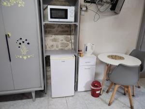 a small kitchen with a small table and a microwave at Chambre gîte du Gardoir in Boresse-et-Martron