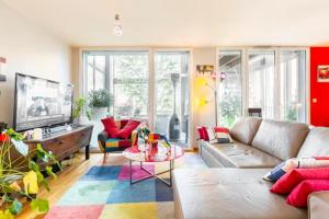 sala de estar con sofá y TV en Location chambre privée avec salle de bain et WC privatifs dans appartement moderne en Nantes