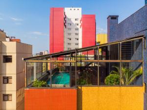 a building with a pool in the middle of a city at Slaviero Curitiba Shopping in Curitiba