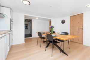 a kitchen and dining room with a wooden table and chairs at Moderne & Fuldt udstyret lejlighed m.plads til 4 in Højbjerg