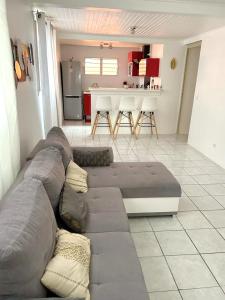 a living room with a couch and a kitchen at Villa de 2 chambres avec vue sur la ville piscine privee et jardin clos a Le Lamentin in Le Lamentin