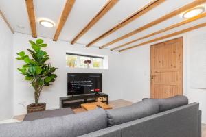 uma sala de estar com um sofá e uma televisão em Moderne & Fuldt udstyret lejlighed m.plads til 4 em Højbjerg