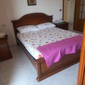 1 cama con edredón morado y 2 almohadas en Rosa di Calabria, en Bovalino Marina