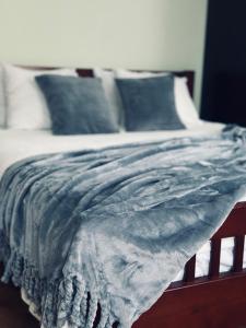 a bed with a blue blanket on top of it at Apartamenti DVINSKA in Daugavpils