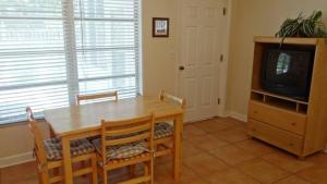 a dining room with a wooden table and a tv at Street South House #54587 in Bradenton Beach