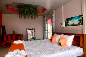 sypialnia z dużym łóżkiem z pomarańczowymi poduszkami w obiekcie Heaven Guesthouse w mieście Pakxé