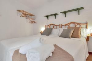 um quarto com 2 camas e lençóis brancos em Nueva! Casa andaluza acogedora en una localización única em Ojén