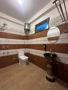 a bathroom with a toilet and a sink and a mirror at Rare House in Kalgha