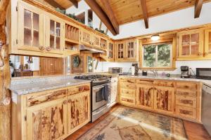 een keuken met houten kasten en een fornuis met oven bij 1792- Fishermans Paradise Home in Big Bear Lake
