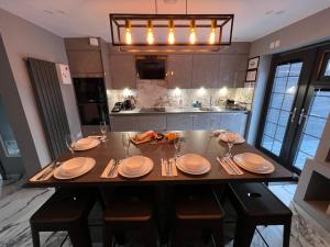 a kitchen with a table with plates and utensils on it at Urban Escape *4 Bedroom House* with FREE Parking in Birmingham
