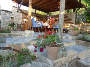a patio with a table and chairs and flowers at Guesthouse & hostel Lorenc in Berat