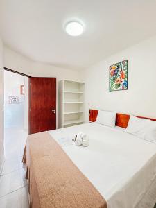 ein Schlafzimmer mit einem großen weißen Bett in einem Zimmer in der Unterkunft POUSADA MAR BELLO in Paripueira