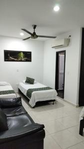 a bedroom with two beds and a ceiling fan at Hotel Bellagio in Barrancabermeja