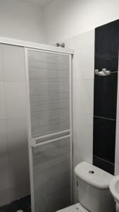 ein Bad mit einer Dusche, einem WC und einem Waschbecken in der Unterkunft Hotel Bellagio in Barrancabermeja