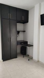 ein leeres Zimmer mit schwarzen Schränken und einem Schreibtisch in der Unterkunft Hotel Bellagio in Barrancabermeja