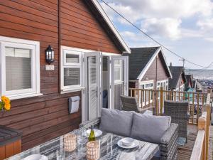 a patio with a table and chairs on a deck at Marnie's Rest in Lyme Regis