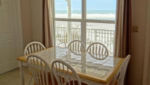a dining room table and chairs with a view of the beach at North Shore Duplex #54588 Duplex in Anna Maria