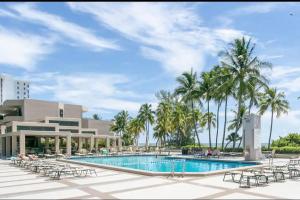 a resort with a pool and chairs and palm trees at KEY BISCAYNE BEACH VACATION #3 in Miami