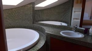 ein Badezimmer mit 2 Waschbecken und einer Badewanne in der Unterkunft B & B Paradiso in Loreto