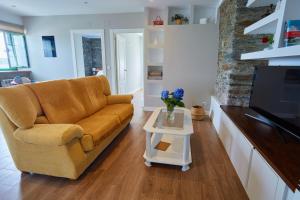 Casa Choureiro Apartamentos Rurales في نافيا: غرفة معيشة مع أريكة وطاولة