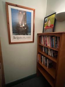 a picture hanging on a wall next to a book shelf at Stackhouse flat in Burnley