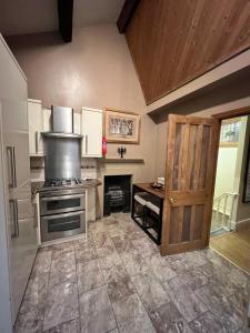 a kitchen with a stove and a wooden door at Stackhouse flat in Burnley