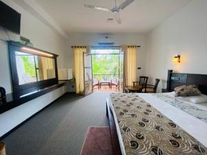 Cette chambre dispose d'un grand lit et d'un balcon. dans l'établissement River Park Hotel - Hikkaduwa, à Hikkaduwa