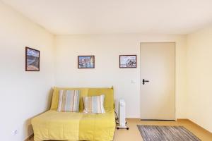 a bedroom with a bed with a yellow blanket at Casa T1 Área Metropolitana do Porto in Carregosa