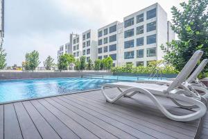 a chair sitting on a deck next to a swimming pool at D'Summit Tropika - 2 Rooms 4 Pax, Free Parking in Johor Bahru