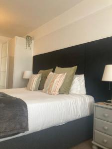 a bedroom with a large bed with a black headboard at The Esplanade in Weymouth