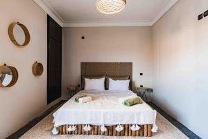 a bedroom with a large white bed with two tables at Central Majorelle Apartment Sleeps 4 in Marrakesh