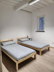 three beds in a room with a window at Come a casa vostra in Lucca