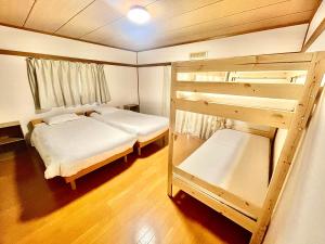 Yellow House Niseko في كوتشان: غرفة نوم مع سريرين بطابقين ومرآة