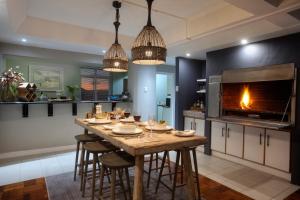 a kitchen with a table with chairs and a fireplace at Cape Recife Lighthouse Luxury Villa in Port Elizabeth