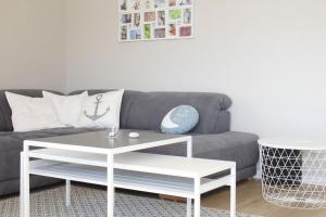 sala de estar con sofá gris y mesa de centro blanca en Ferienhaus Fine, en Gross Schwansee