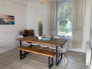 - une salle à manger avec une table et des chaises en bois dans l'établissement Seagulls by Bloom Stays, à Folkestone