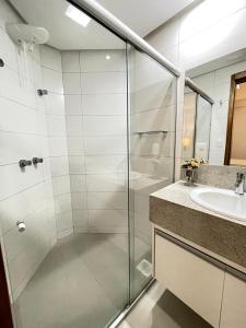 een badkamer met een douche en een wastafel bij Flat inteiro Ônix Bueno in Goiânia