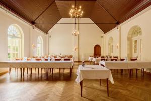 a large room with white tables and chairs in it at Waldhotel Forsthaus Hainholz in Pritzwalk