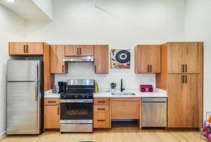 a kitchen with wooden cabinets and stainless steel appliances at The Music Booth - walk to restaurants and bars in Chattanooga