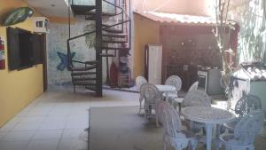 a patio with tables and chairs and a spiral staircase at Morro Hostel e Pousada in Morro de São Paulo